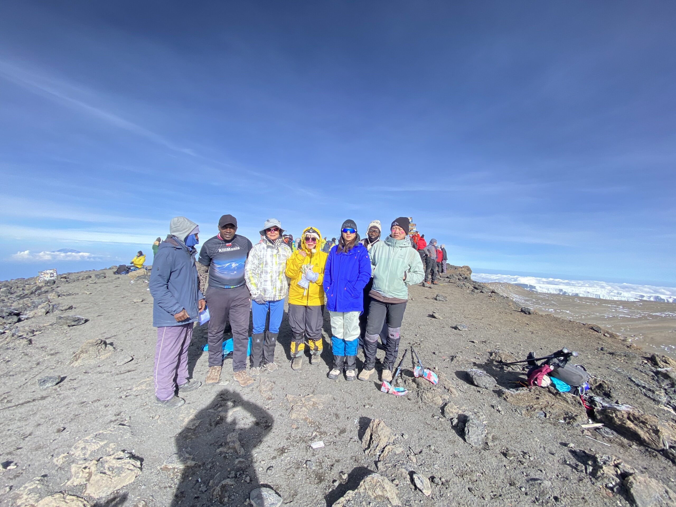 Can a Beginner Climb Kilimanjaro? The Honest Answer From Sabinus Msimba | Kilimania Adventure Can a Beginner Climb Kilimanjaro? Sabinus Msimba second from left with beginner Kilimanjaro climbers celebrating at Uhuru Peak summit on Mount Kilimanjaro, Tanzania.