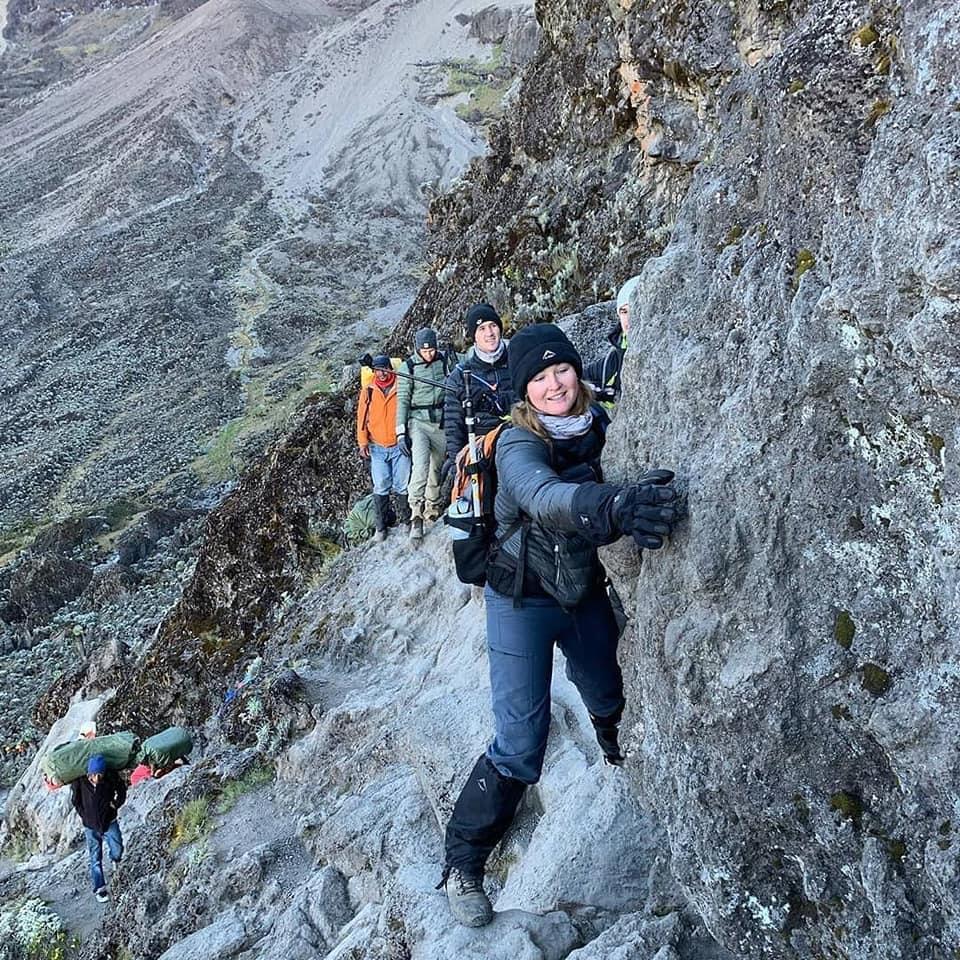 Climber navigating the Kissing Rock section of the Barranco Wall on Mount Kilimanjaro during an Umbwe Route ascent guided by Senior Guide Sabinus Msimba.