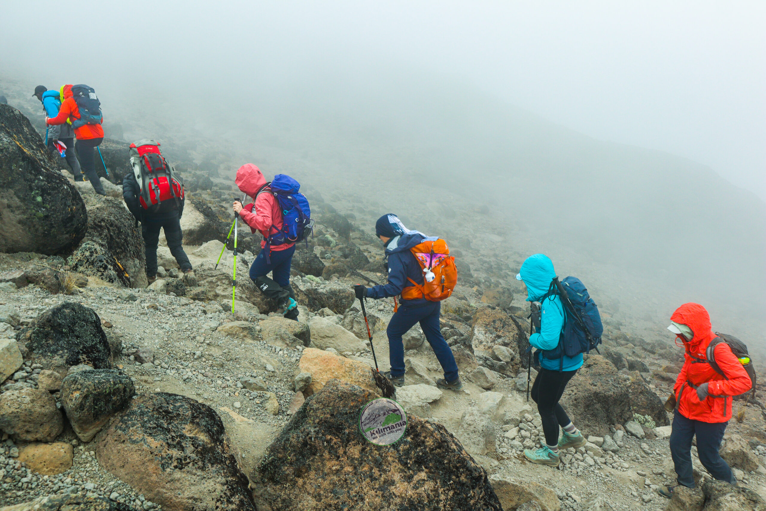 Climbers walking toward Lava Tower across Kilimanjaro's alpine desert in waterproof hiking boots