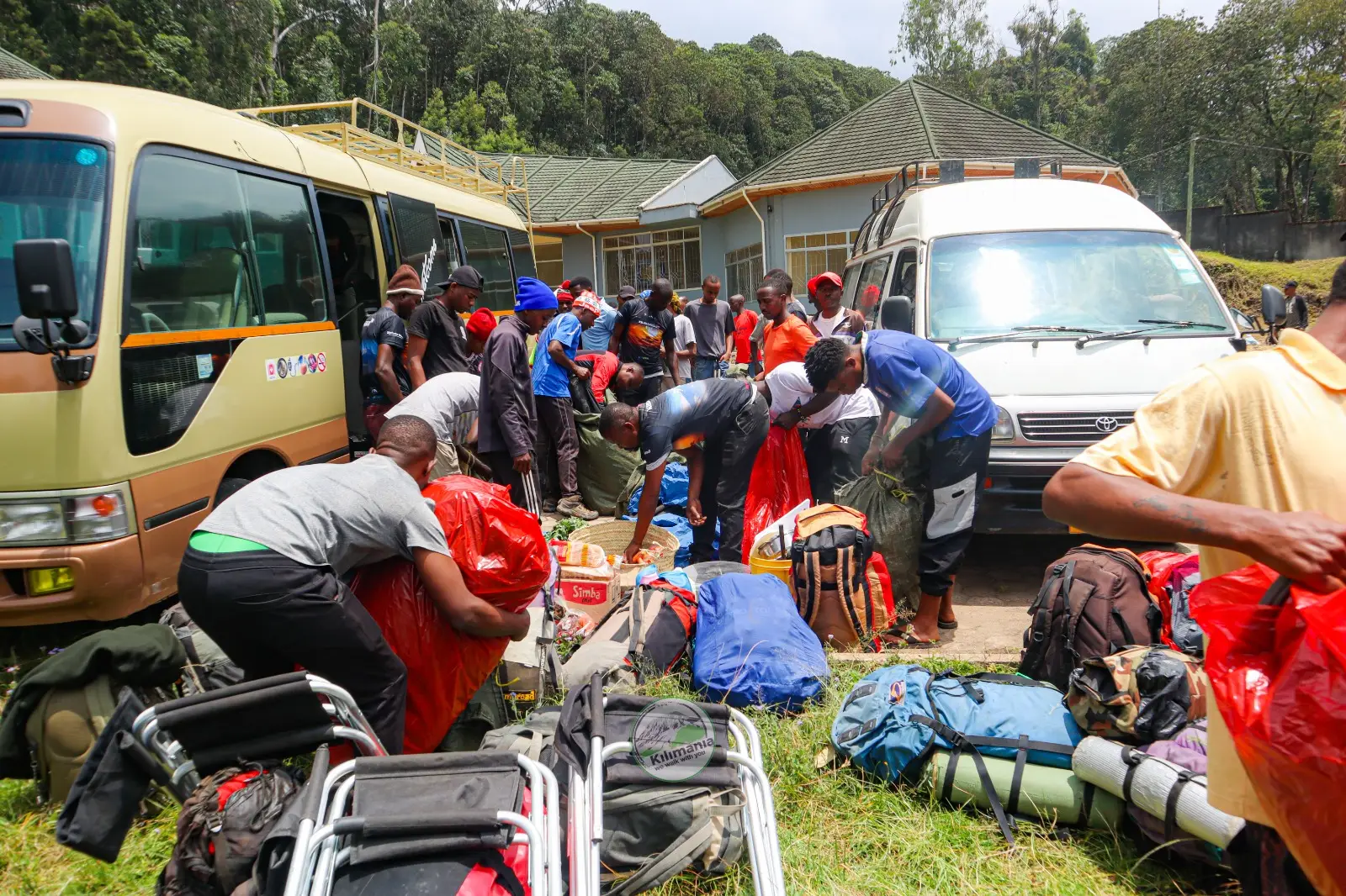 Kilimania Adventure guides and porters preparing equipment at Machame Gate, Mount Kilimanjaro.
