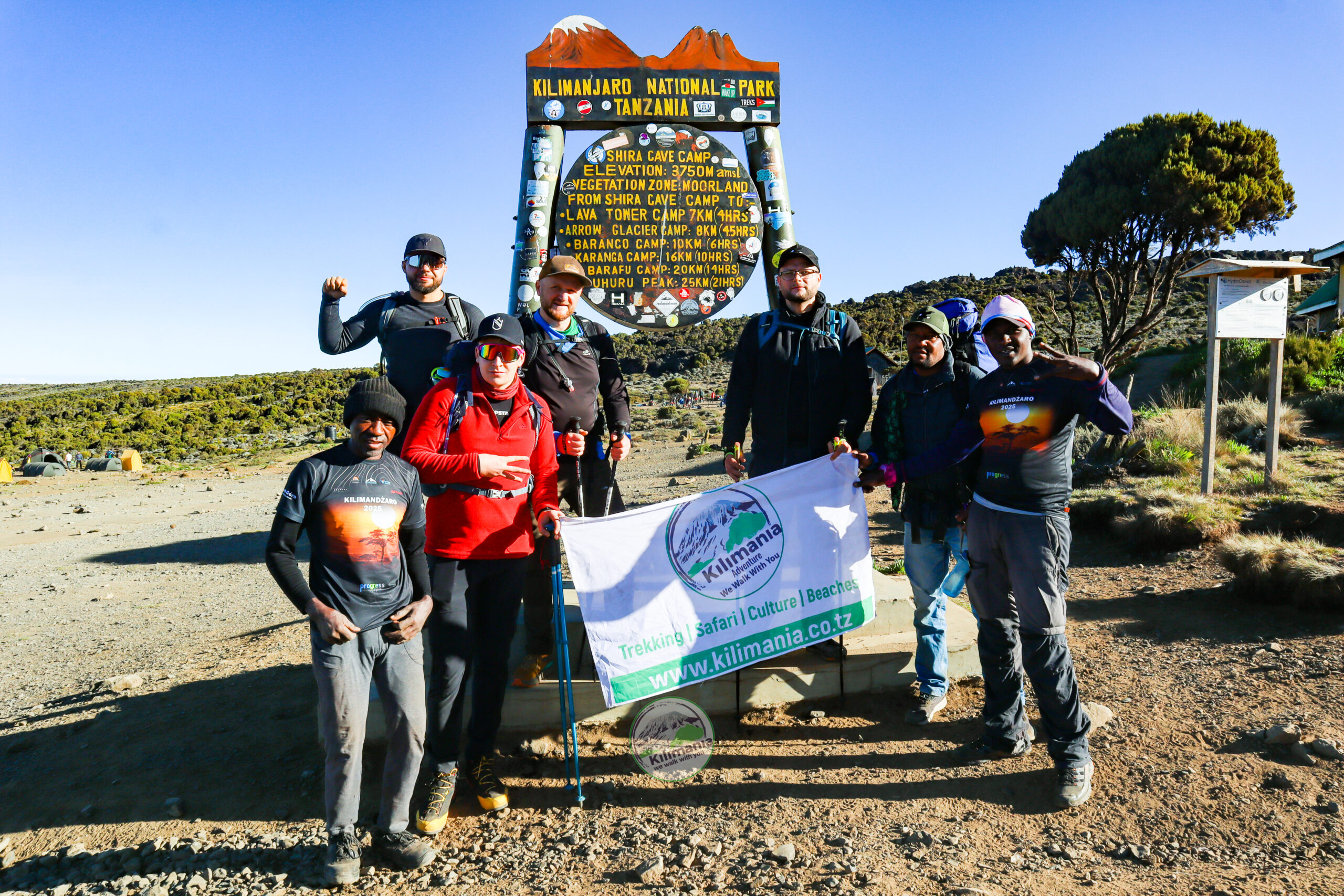 Guide Sabinus Msimba with climbers at Shira Cave Camp during a gear and boot check on the Lemosho Route