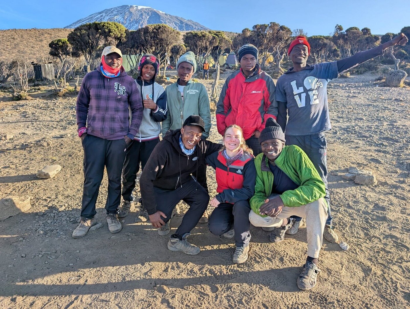 Sabinus Msimba: Senior Kilimanjaro Guide With 22 Years of Experience on Mount Kilimanjaro | Kilimania Adventure Senior guide Sabinus Msimba (first left) and the Kilimania adventure team at high camp on Lemosho 8‑day route, morning after summit – Kilimanjaro success rate by route