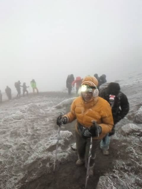 Climbers with headlamps ascending Kilimanjaro during summit night in pre-dawn darkness — the coldest and most demanding phase of any Kilimanjaro climb