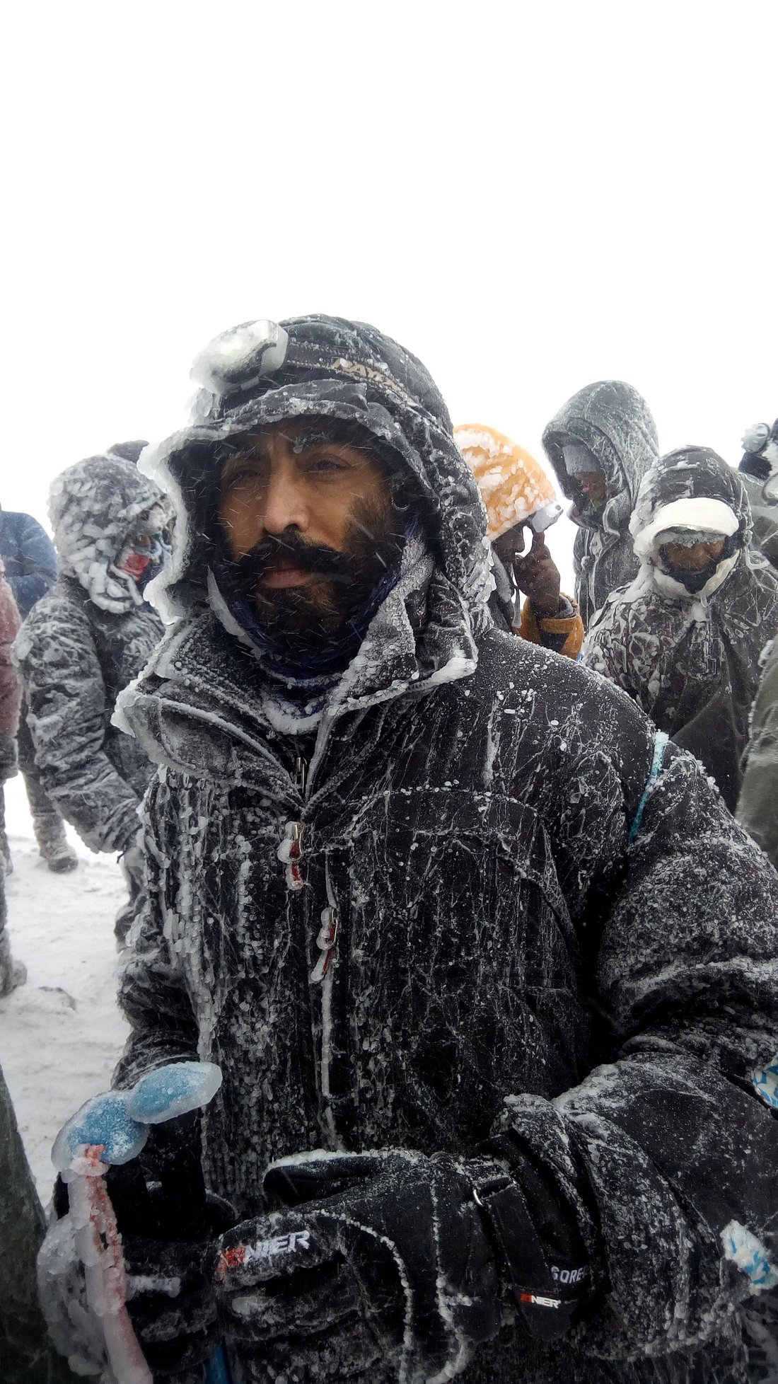 Climber battling snow and strong winds at Uhuru Peak Kilimanjaro