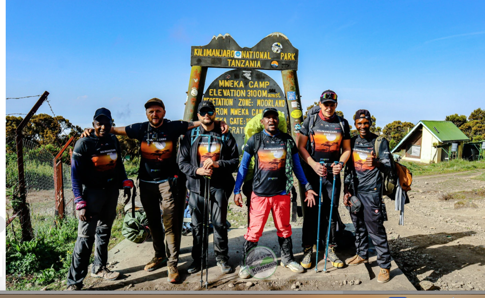 Senior Guide Sabinus Msimba (left) celebrates with Chief Guide Isack, Guide Saimon Bashemera, and climbers at Mweka Camp following a successful summit of Kilimanjaro via the Machame Route, Tanzania 2026