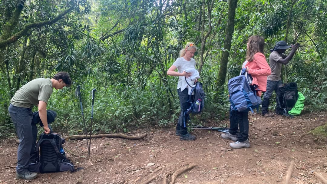 A mother and her two children organizing trekking gear in Moshi before their family Kilimanjaro climb on the Lemosho Route 2026