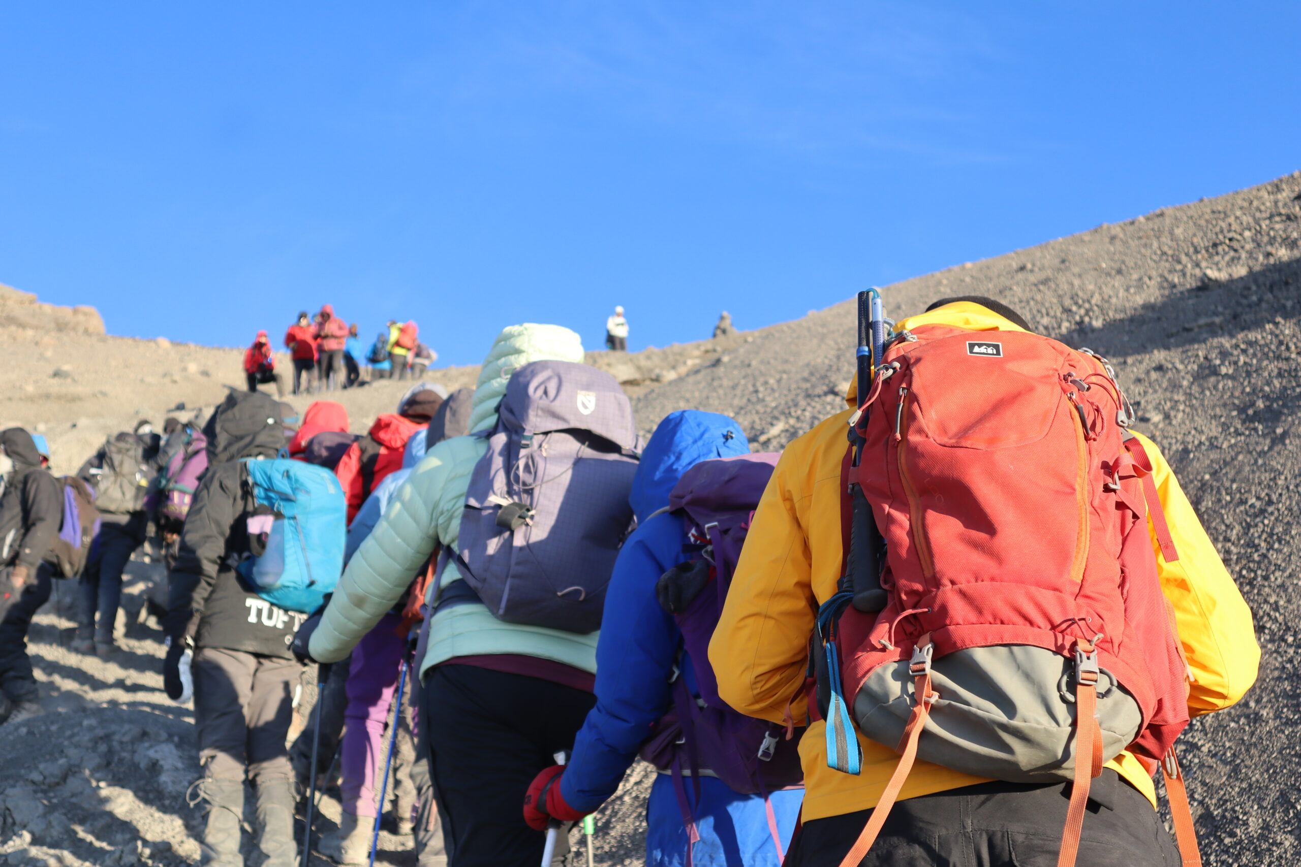 Climbers ascending scree by headlamp on summit night between Barafu Camp and Stella Point at 5,000m — Mount Kilimanjaro summit push