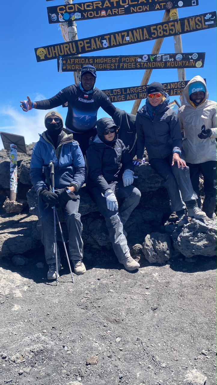 A mother with her son and daughter celebrating at Uhuru Peak 5895m after their 8-day Lemosho Route family Kilimanjaro climb — family Kilimanjaro climbing success July 2026