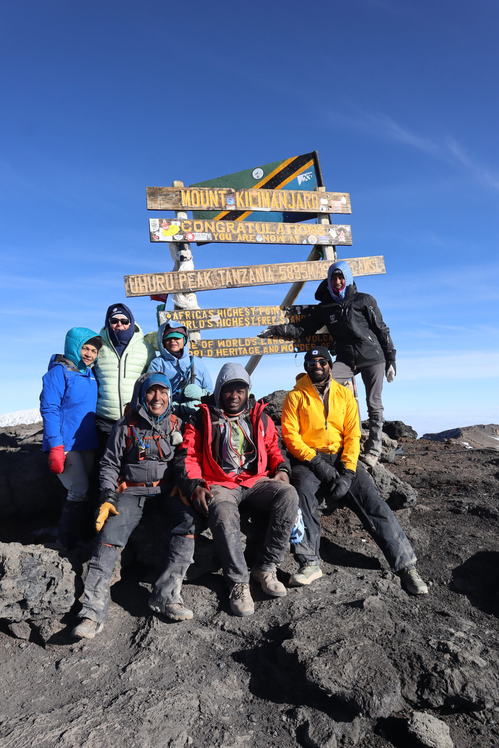 Sabinus Msimba standing at the Uhuru Peak summit sign, 5,895m, Mount Kilimanjaro