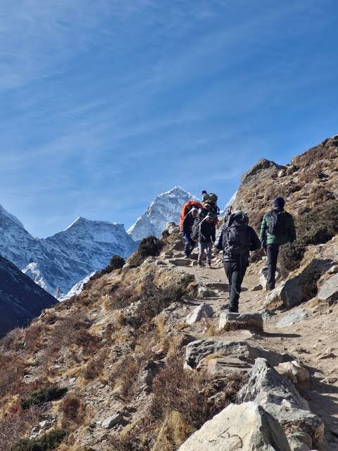 Hikers walking through cloud forest on the Classic Inca Trail in Peru with Inca ruins visible along the trail