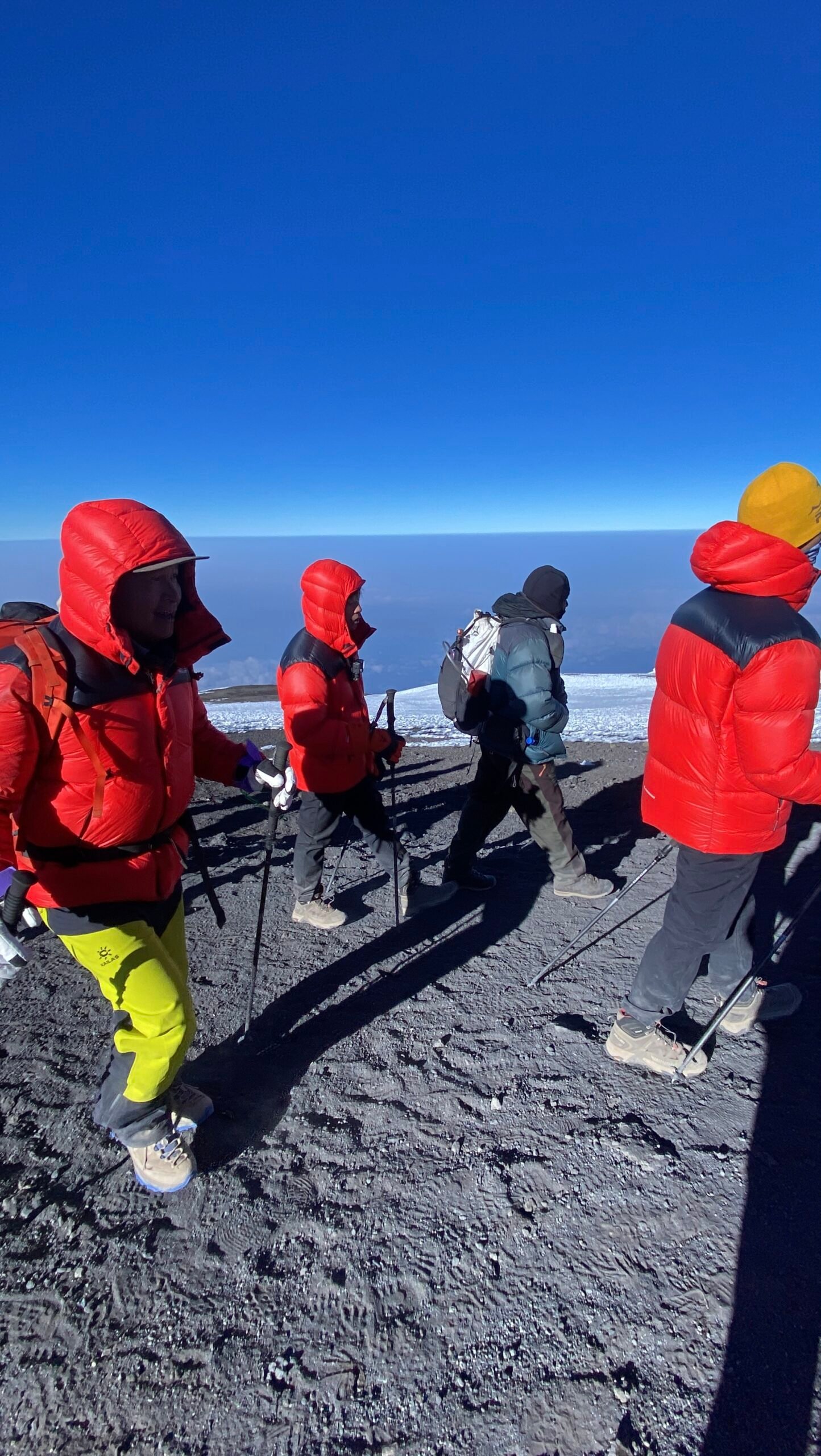 Senior Guide Sabinus Msimba leading climbers through Kilimanjaro's alpine desert zone above 4,500m during a high-altitude trek