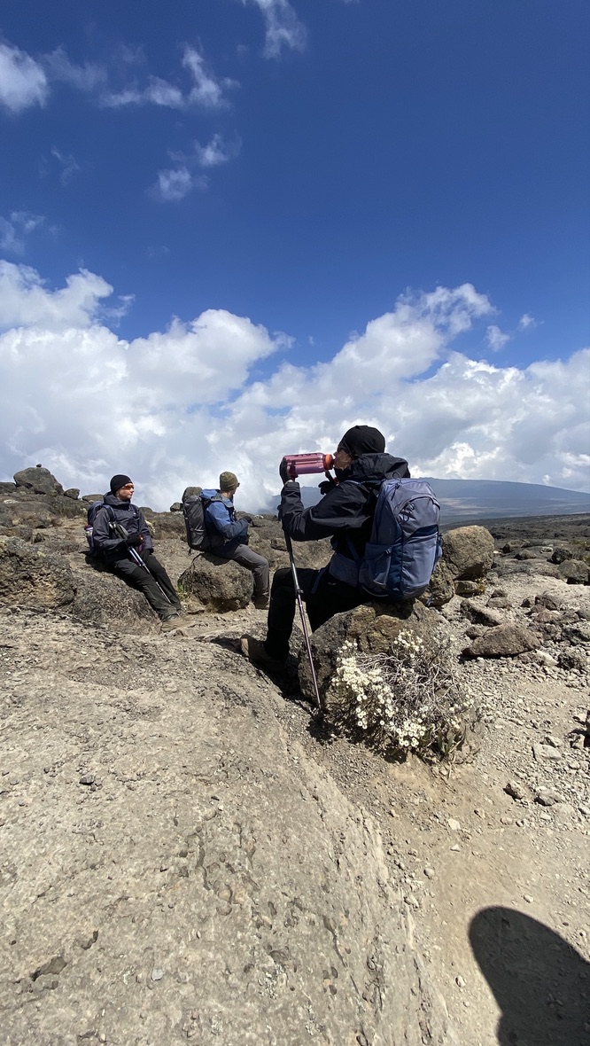 Climbers resting and drinking water at high altitude on Kilimanjaro
