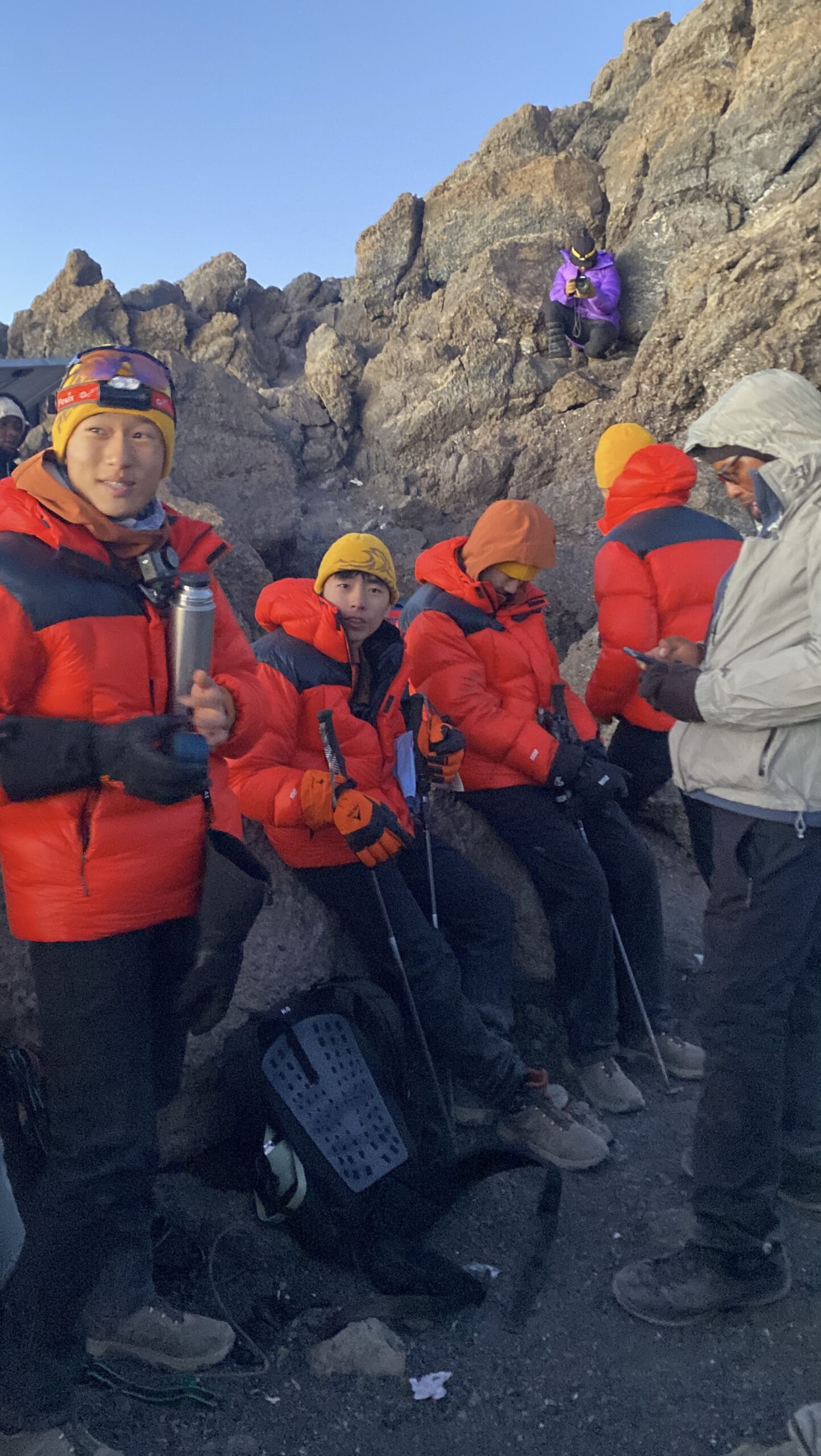 Climbers resting at Gilman's Point at sunrise during summit night on the Marangu Route