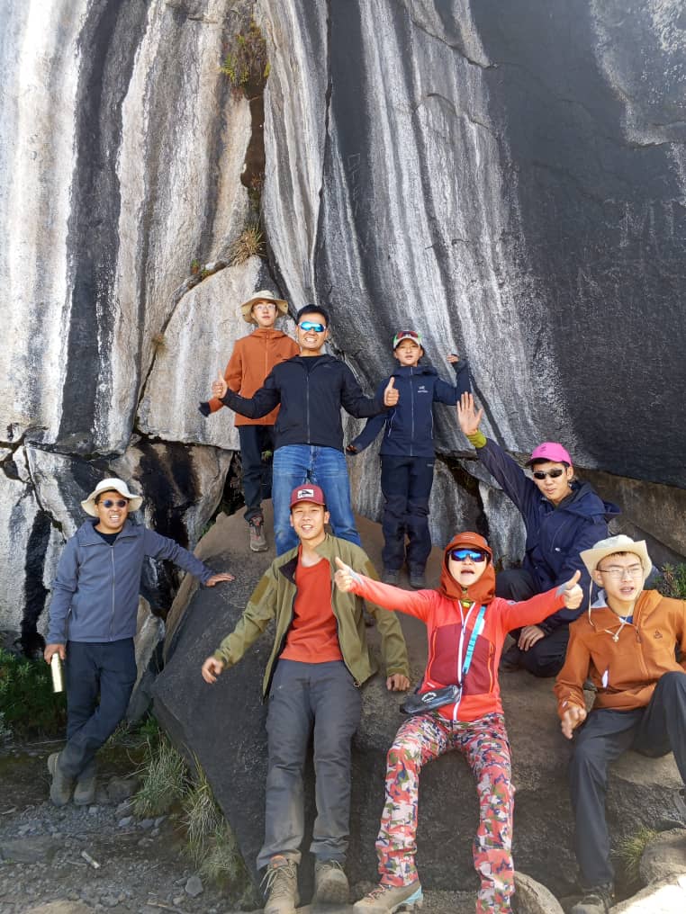 Eight climbers at the Zebra Rock formation during the acclimatization hike on the Marangu Route