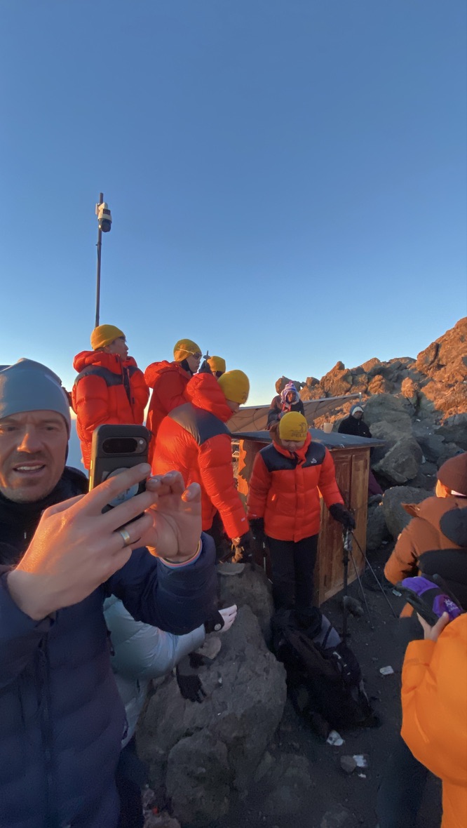 Climbers walking on rocky terrain at a high camp on Kilimanjaro, part of the route covered by TTCL's network expansion