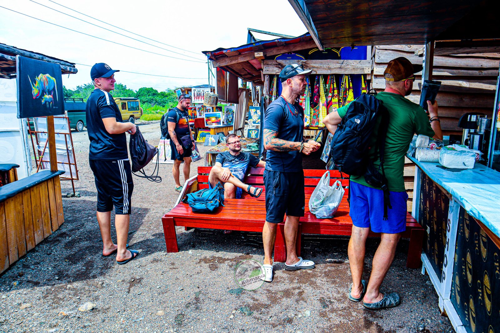 Visitors browsing local souvenirs and kitenge fabric near the Chemka Hot Springs entrance