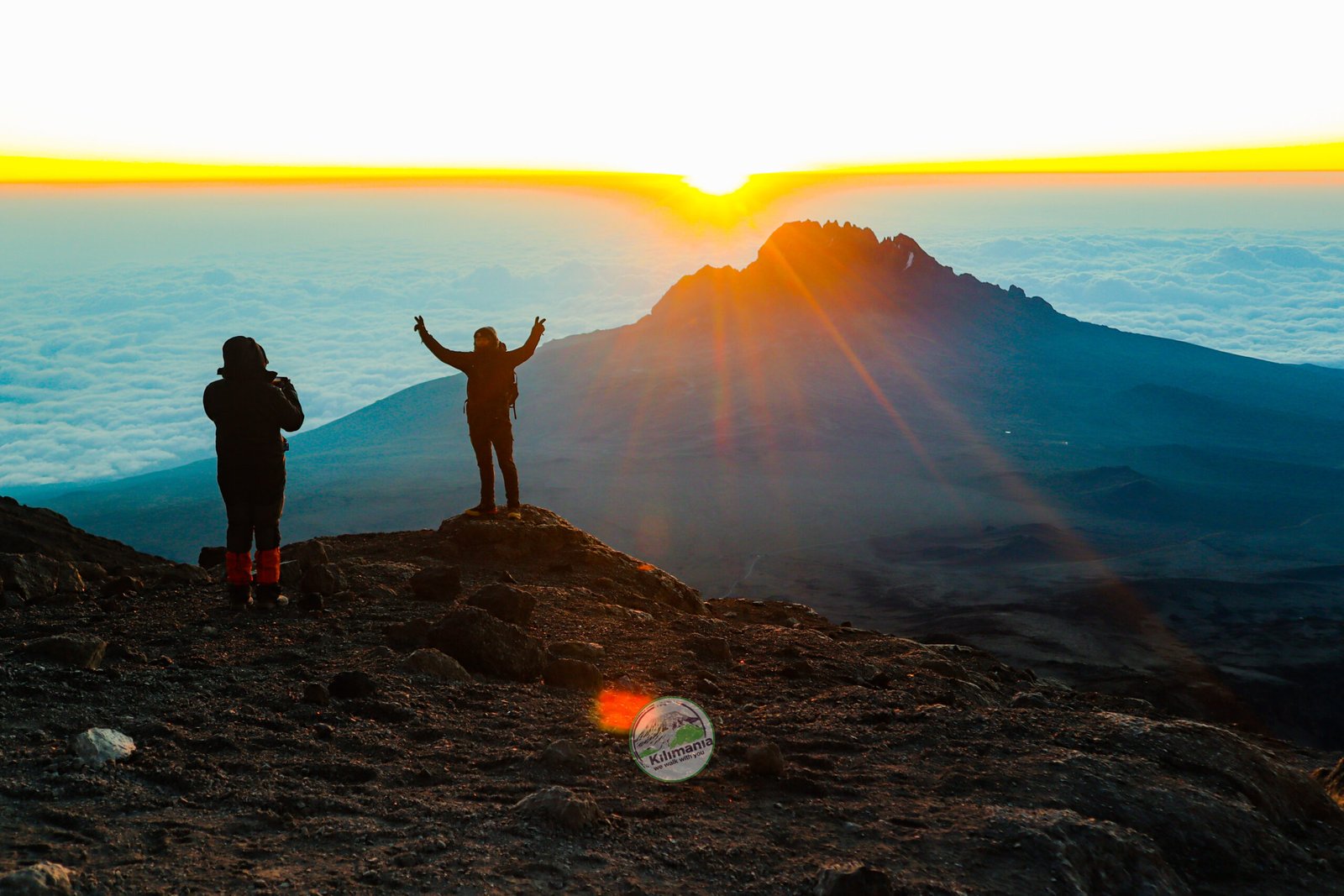 Climbers celebrating sunrise at Uhuru Peak, Kilimanjaro's summit