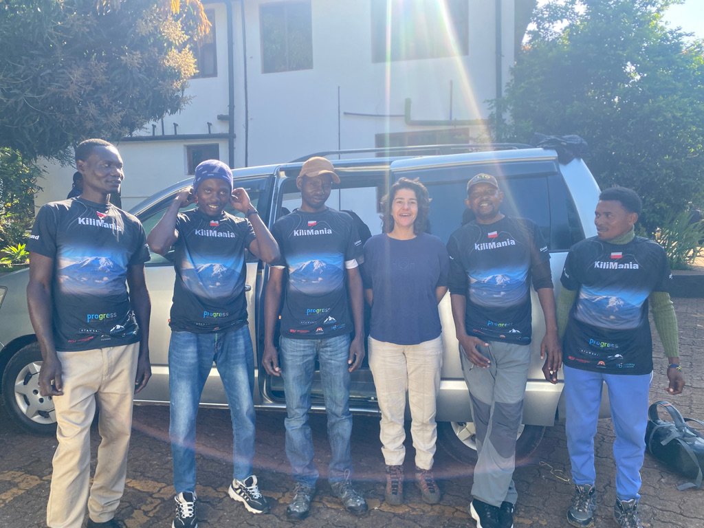 Kilimania Adventure guides and a guest standing beside a 4x4 vehicle before a Shira Plateau day trip departure