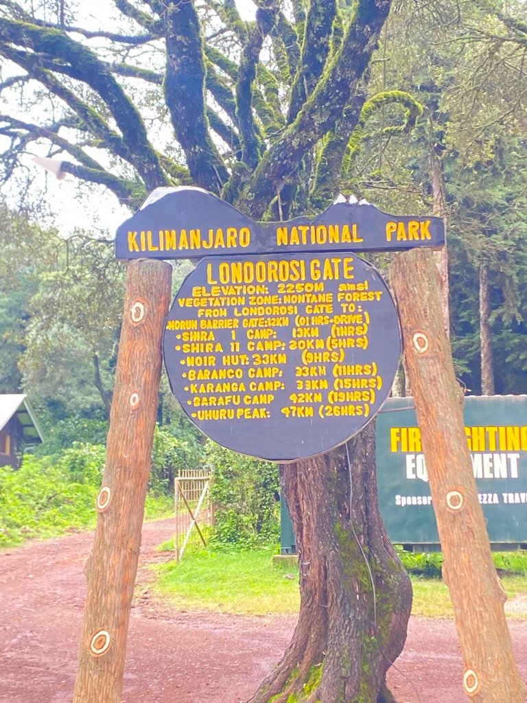 Official Kilimanjaro National Park Londorossi Gate sign showing elevations and distances to camps