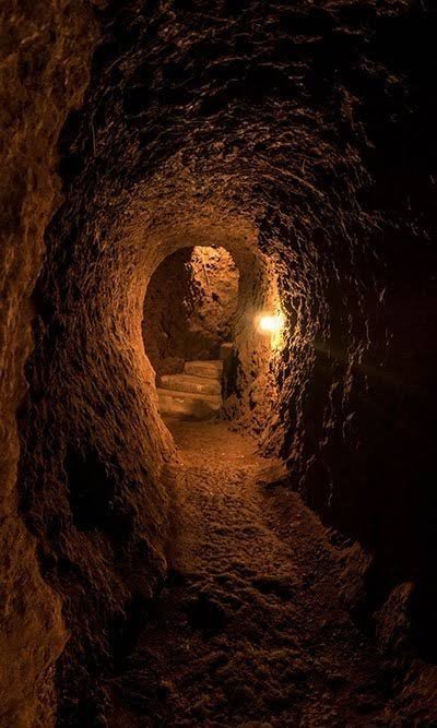 Interior of a Chagga defense cave tunnel near Marangu, lit by flashlight