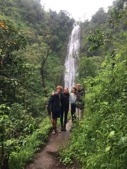 Visitors walking the farmland trail toward Ndoro Waterfalls near Marangu