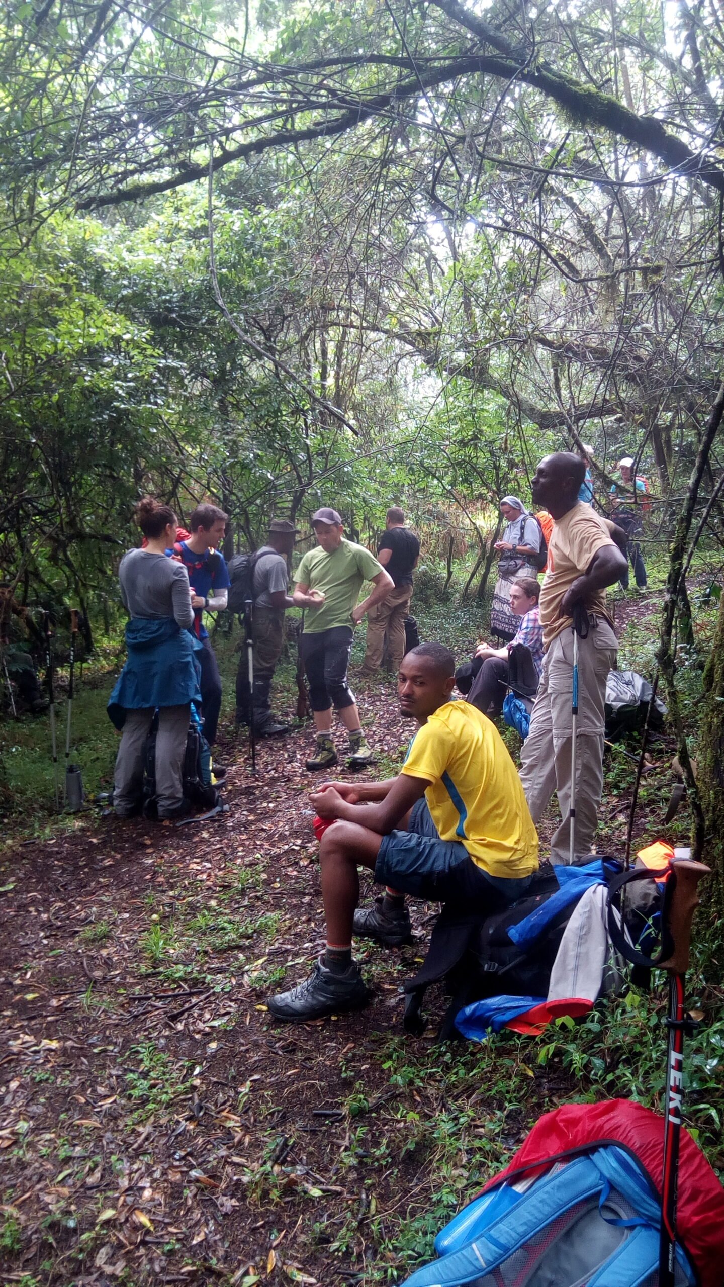 Hikers resting on a forest trail during the Mount Meru day hike